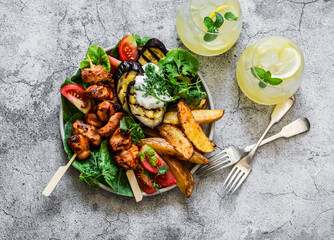 Teriyaki chicken skewers, roasted potatoes, vegetables, grilled eggplant and lemon mint cocktail -...
