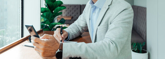 online training a student writes the text of a lecture from their phone to a Notepad. banner