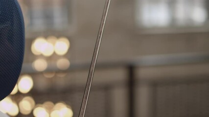Close-up of the head of an unidentified female fencer in a mask fighting an unidentified enemy. The concept of women fencers. Young woman athlete fencer starts a fight - Powered by Adobe