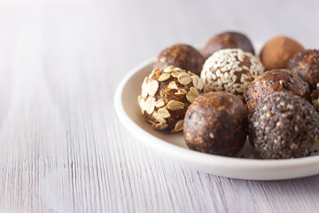 Raw vegan healthy energy balls with oatmeal, chia seed, coconut flakes, cocoa and dried fruits. No cook energy bites.