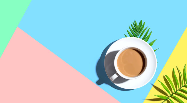 A cup of coffee with tropical leaves - flat lay