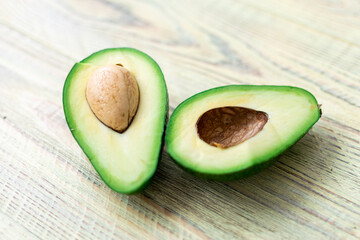 Avocado cut in half on a wooden background.