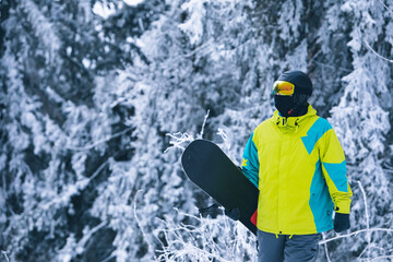 Fototapeta na wymiar man with snowboard walking by snowed hill