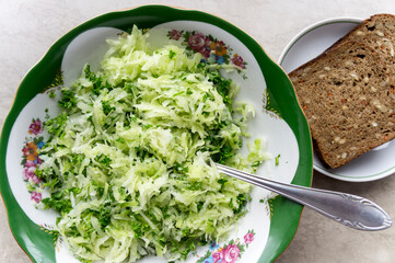 Simple fresh salad with grated radish and chopped parsley with a piece of black bread
