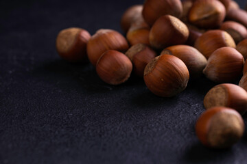 Hazelnuts on dark background. Food background, photo wallpaper.