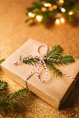 Fototapeta na wymiar Christmas gift and fir branches on golden background 