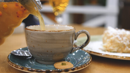 Pouring of sea buckthorn tea into a cup