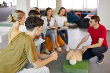 CPR class with male instructor speaking and demonstrating help, giving lessons of first aid....