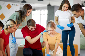 group of young diverse people practice first aid training by hand, first aid course in CPR dummy. concept of training skills to save lives, medicine