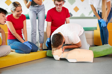 CPR class with young caucasian instructors speaking and demonstrating help first aid, cpr mannequin...