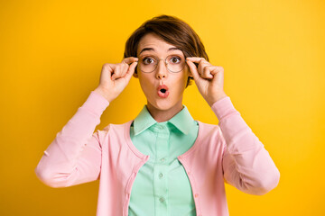 Photo of positive shocked lady hold eyewear open mouth wear turquoise shirt pink cardigan isolated...