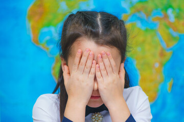 Close-up portrait of smart cute girl on the background of the world map.