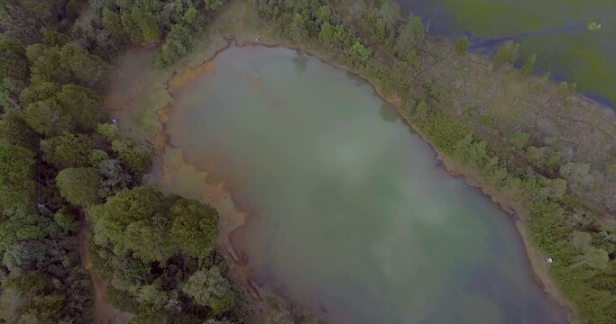 Pristine Green Guarne Lagoon in the Middle of the Woods near Medellin, Colombia on a Cloudy Day shot from in Smooth Travelling form Above