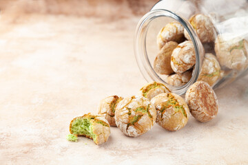 Tasty round cookies with pistachio, scattered from transparent glass bank