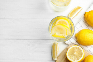 Soda water with lemon slices and fresh fruits on white wooden table, flat lay. Space for text