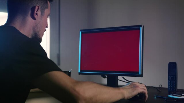 Caucasian man working in a day office. The Error signal appears and hits the computer screen hard and blows it up.