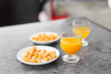Two glasses of yellow drink - poncha -traditional drink of Madeira with a snack