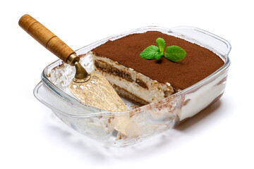 Traditional Italian Tiramisu dessert in glass baking dish and scapula isolatet on white background