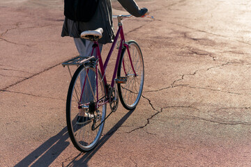 unrecognizable woman with retro bike at sunset
