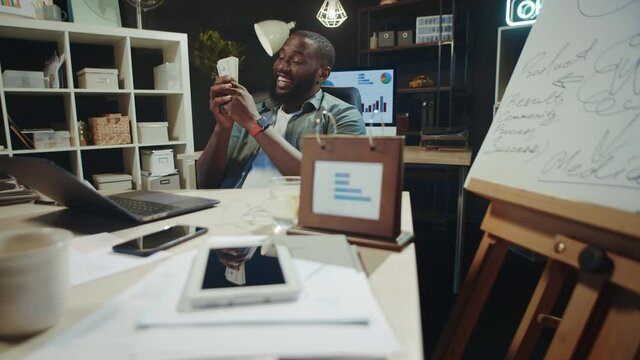 Handsome african american business man enjoying money smell in hipster office.