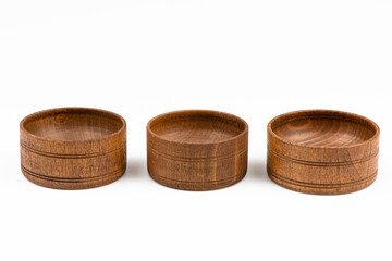 Three wooden bowls for spices isolated on a white background.