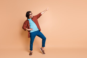 Full length profile photo of guy dance direct finger up wear spectacles brown t-shirt pants...
