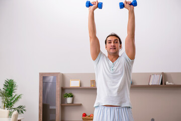Fototapeta na wymiar Young man doing sport exercises at home