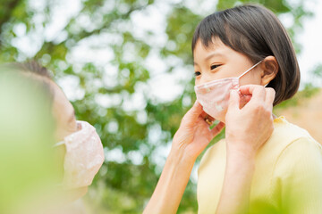 孫にマスクをつける祖母