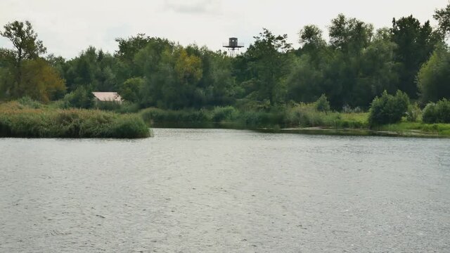 Border Intelligence Tower Among The Trees On The Other Side Of The River.