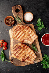 grilled pork steaks with spices on a stone background