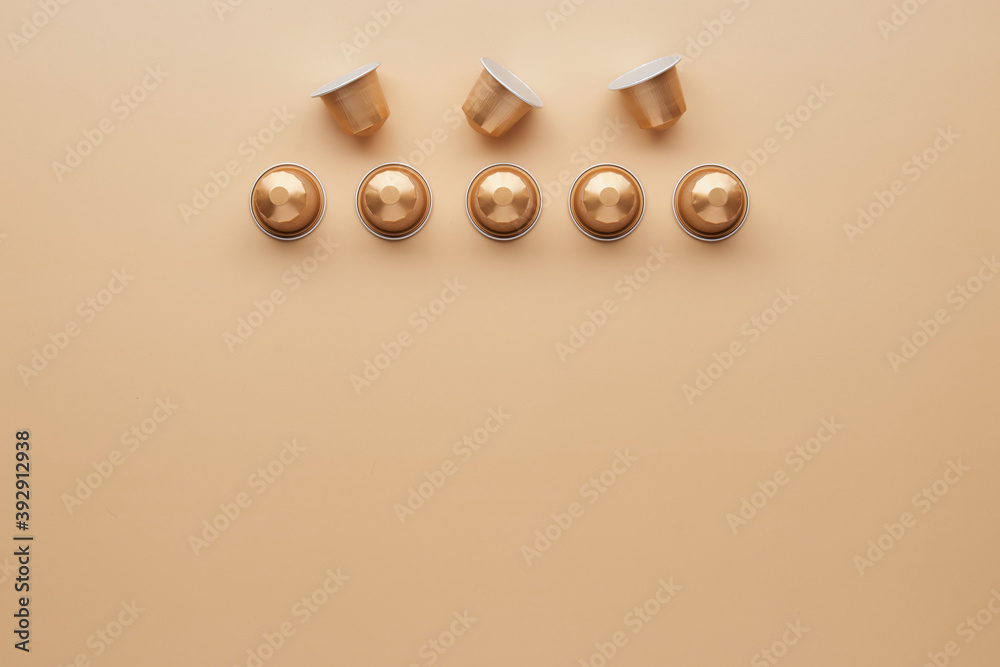 Wall mural caffeine, hot drinks and objects concept - close up of golden capsules or pods for coffee mashine on