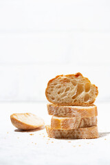 baguette cut into slices on white background, vertical