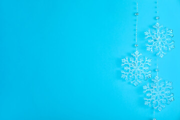 Beautiful decorative snowflakes hanging on light blue background, space for text