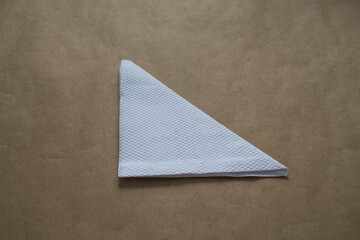 A folded white napkin on a table.