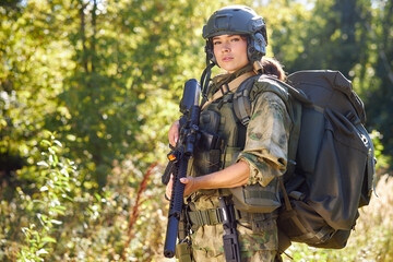 brave caucasian woman is engaged in hunting weapon gun or rifle, wearing military suit. target...
