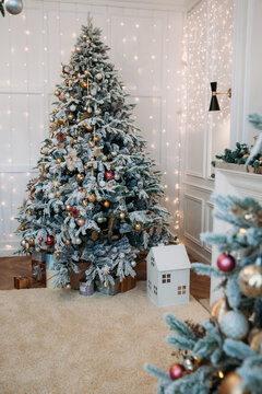 Vretical photograph of a Christmas tree decorated with golden balls, snowflakes, artificial snow and other New Year decorations