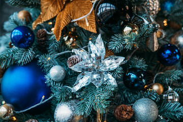 Christmas tree decor with a large linen, a mirror flower, a large blue ball and smaller balls