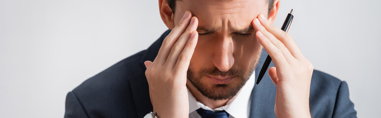 Tired businessman with migraine, holding hands near temples on white background, banner