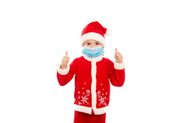 Fototapeta na wymiar Little boy showing thumbs up, dressed in santa claus costume