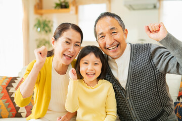 家で休日を楽しむ祖父母と孫