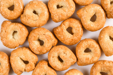 Taralli or tarallini, traditional italin snack from wheat dough. Background from some pieces close-up isolated on white.