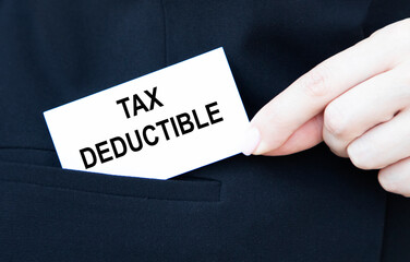 The businessman puts the card in his pocket with the text TAX DEDUCTIBLE.