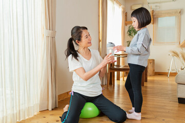 自宅で運動する祖母と孫