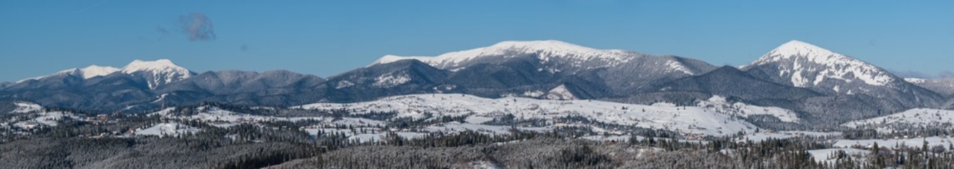 Winter remote alpine village outskirts, countryside hills, groves and farmlands view from mountain...