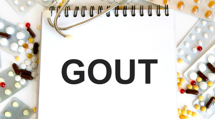 In the notebook is the text of GOUT, next to blisters with tablets and capsules.