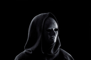 Portrait of a scary figure in hooded cloak isolated on black