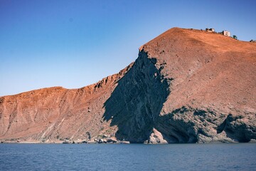 Fototapeta na wymiar Red mountain on the coast view from the sea
