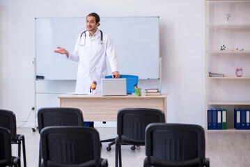 Naklejka na ściany i meble Young male doctor giving seminar in the classroom