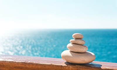 Zen relax background. A pyramid of stones on the beach in clear sunny weather. Background for meditation, yoga and massage
