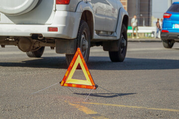 Naklejka premium On the road, on which cars drive, there is a warning triangle.